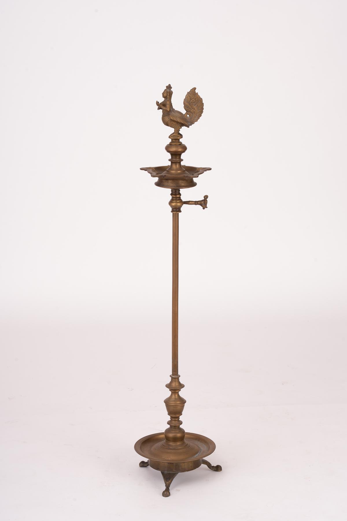 A lamp featuring a kinnara, a creature that is half human and half bird.