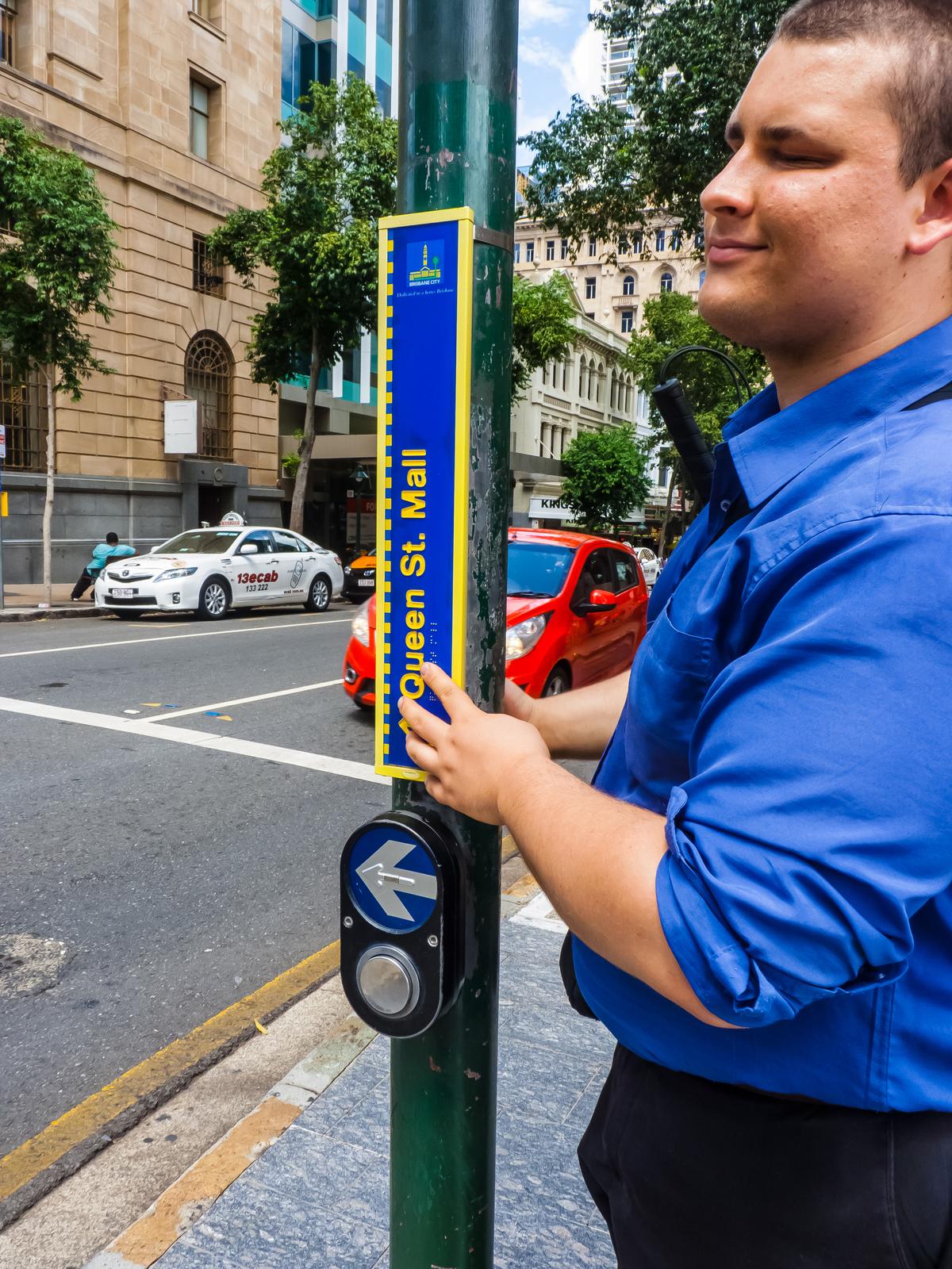 Reading braille tactile road sign.