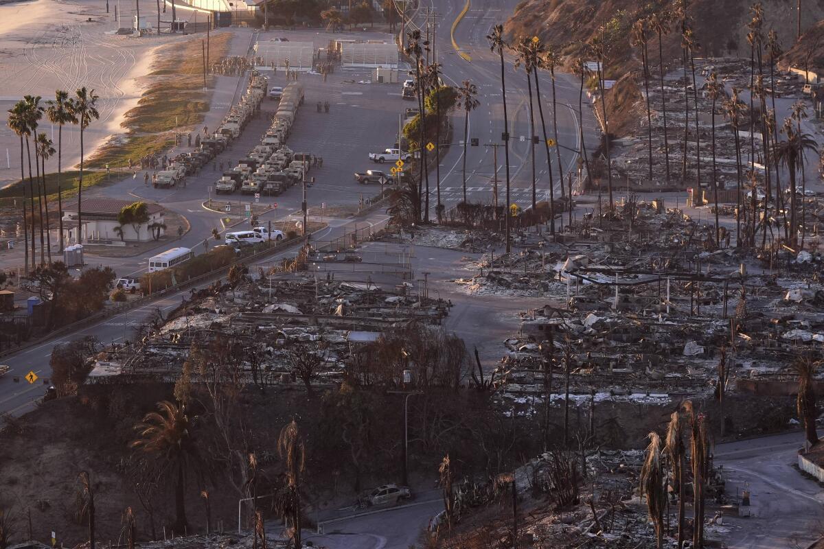 A burned out neighborhood is seen along Pacific Coast Highway after the Palisades Fire, while several National Guard vehicles line up along the beach, Sunday, Jan. 12, 2025. Photo: AP