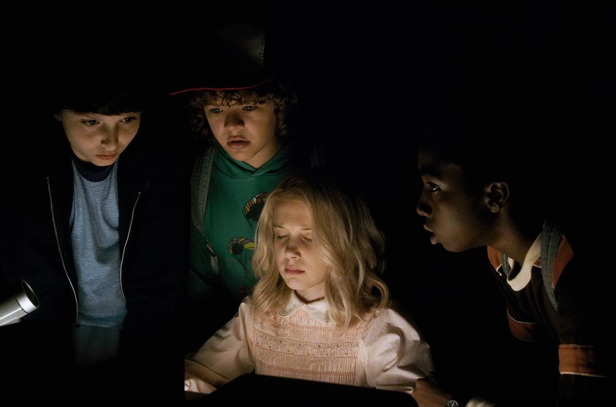 (L-R) Finn Wolfhard as Mike Wheeler, Gaten Matarazzo as Dustin Henderson, Millie Bobby Brown as Eleven and Caleb McLaughlin as Lucas Sinclair, in a still from ‘Stranger Things’