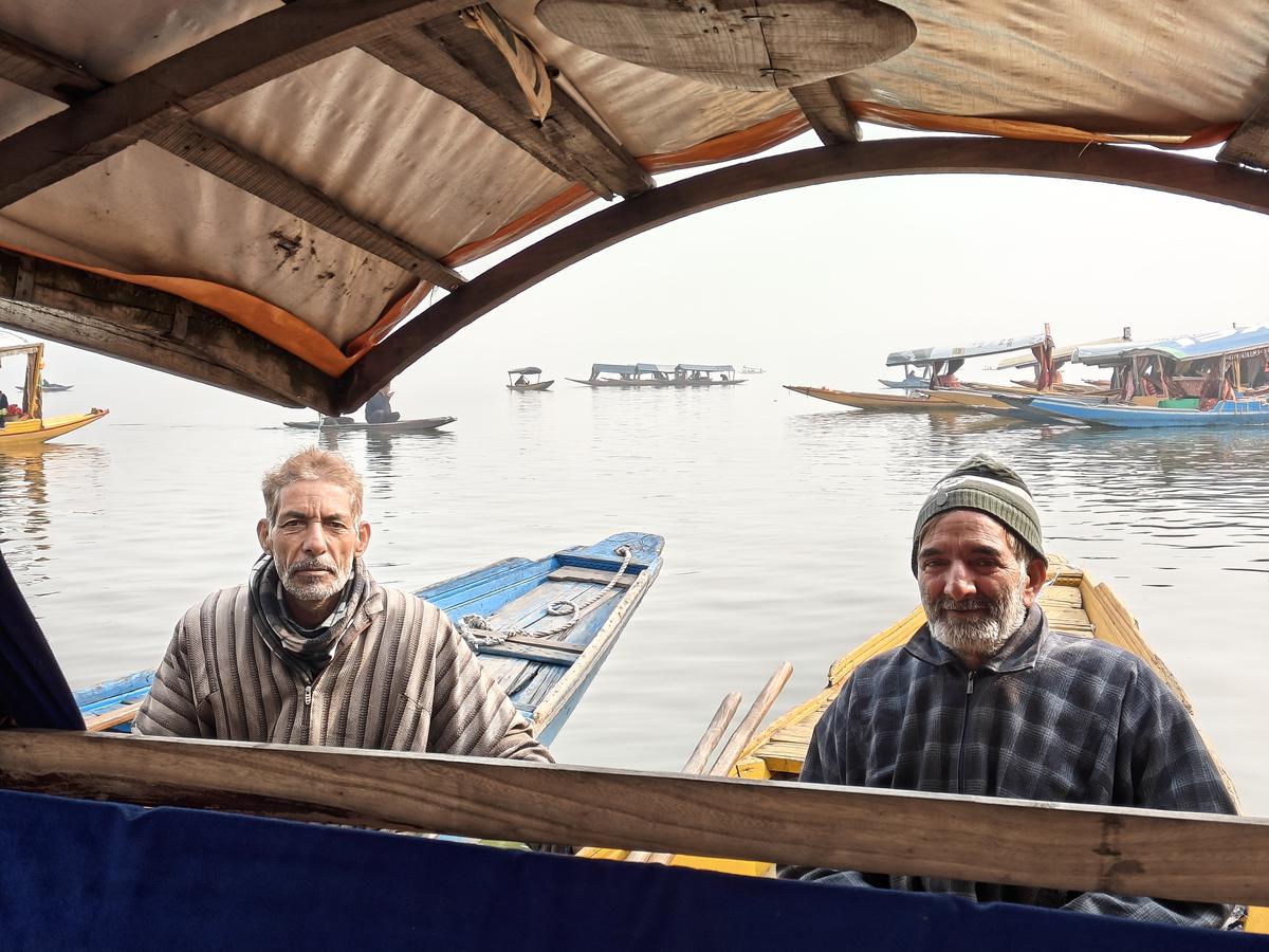 Abdul Ghani (Left) poses for a photo on the Dal Lake in Srinagar, Kashmir