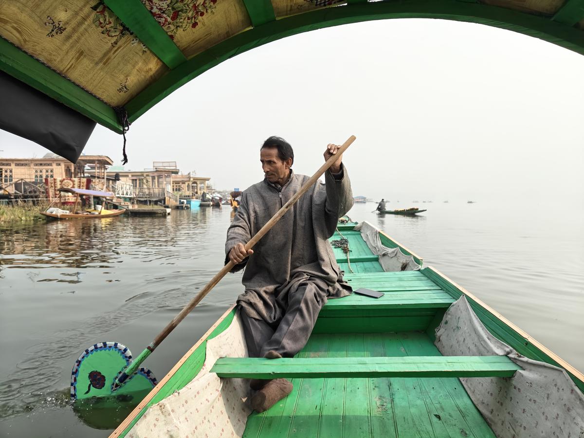 Shikhara owner Abdul paddles across the Dal Lake in Srinagar, Kashmir