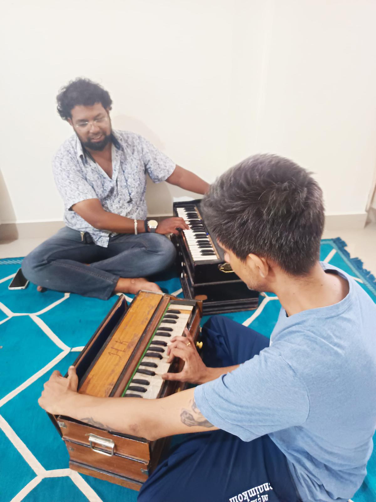 एक विद्यार्थी हारमोनियम सीख रहा है 