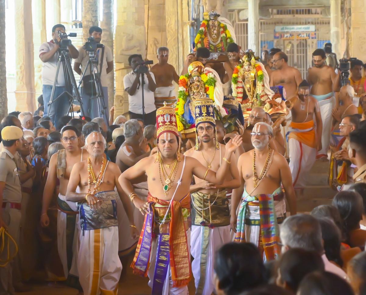 Bharadwajan araiyar (con il copricapo rosso) esegue l'Araiyar Sevai.