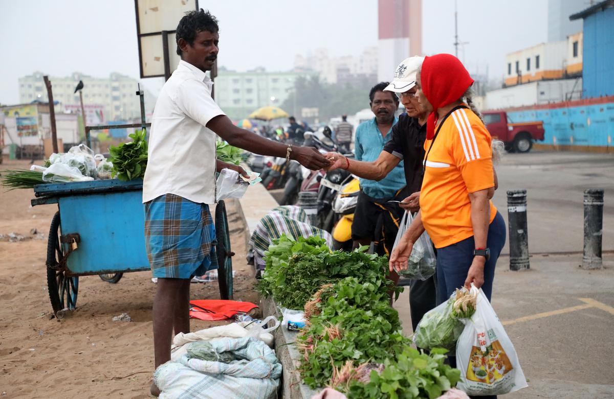 Street vendor sells green spinaches and vegetables at Marina beach every morning.