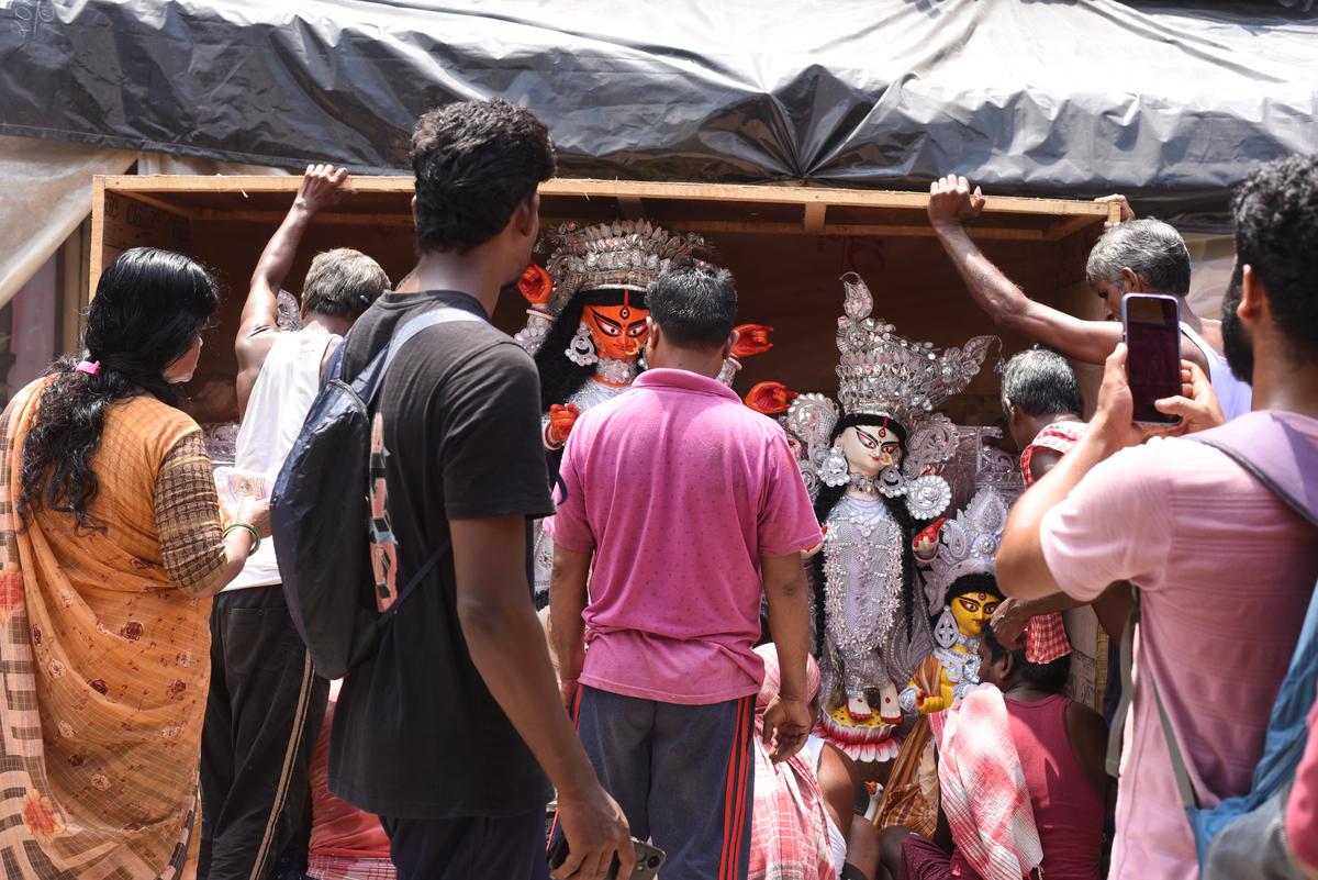 Visitors and influencers take pictures at a shop in Kumartuli. 