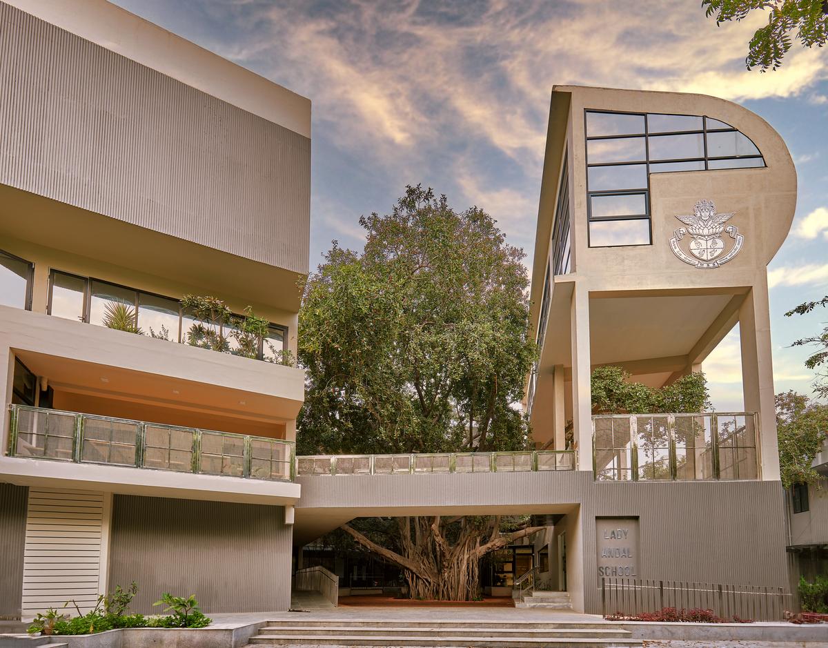 The exterior of Lady Andal IB School, with banyan trees rising from the ground in the neighborhood.