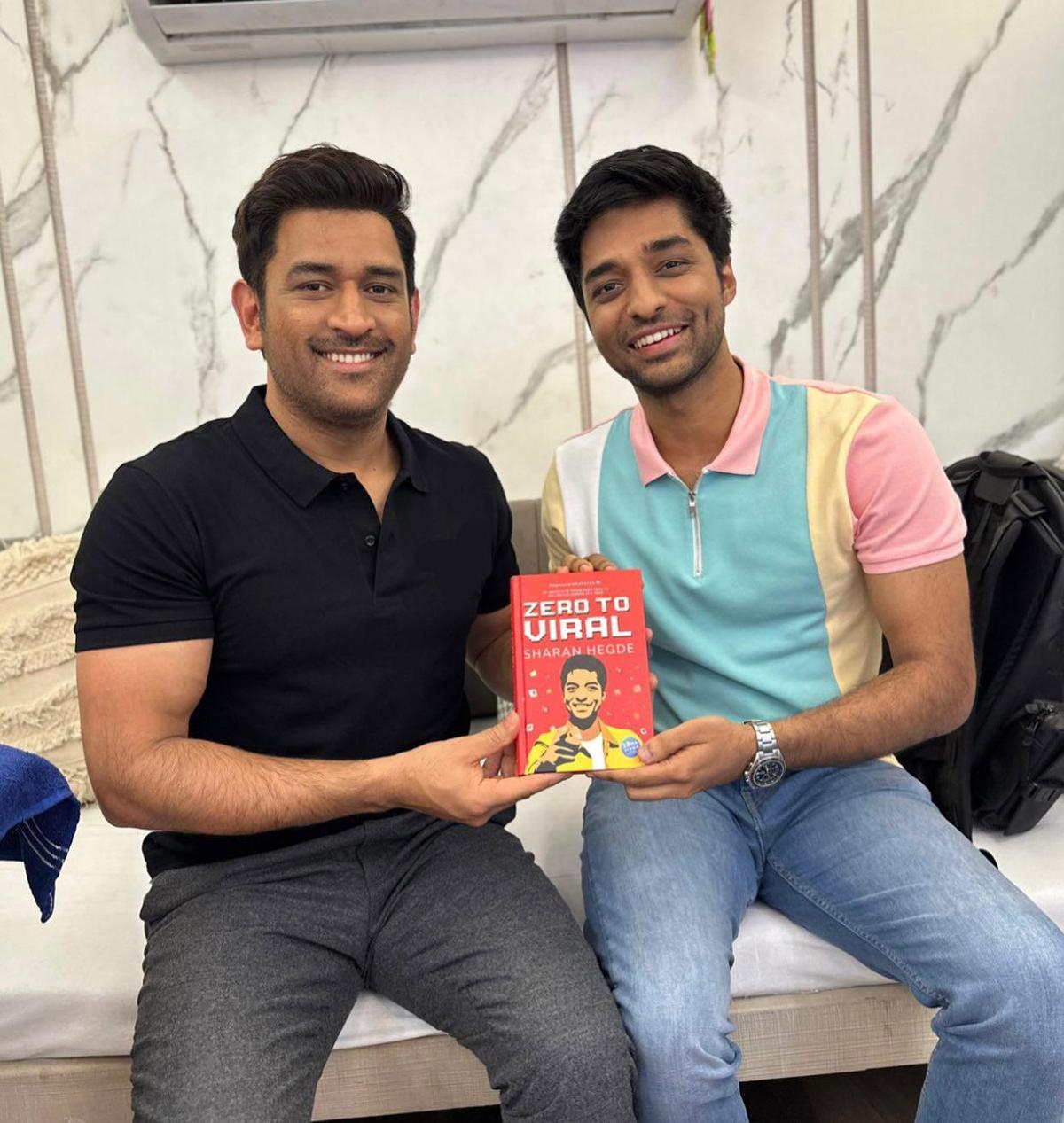Sharan Hegde presenting his book to MS Dhoni