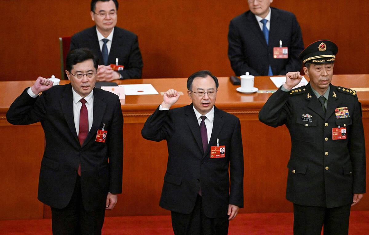 (L-R) Newly-elected Chinese state councilors Qin Gang, Wu Zhenglong and Li Shangfu swear an oath after they were elected during the fifth plenary session of the National People’s Congress (NPC) at the Great Hall of the People in Beijing on March 12, 2023.