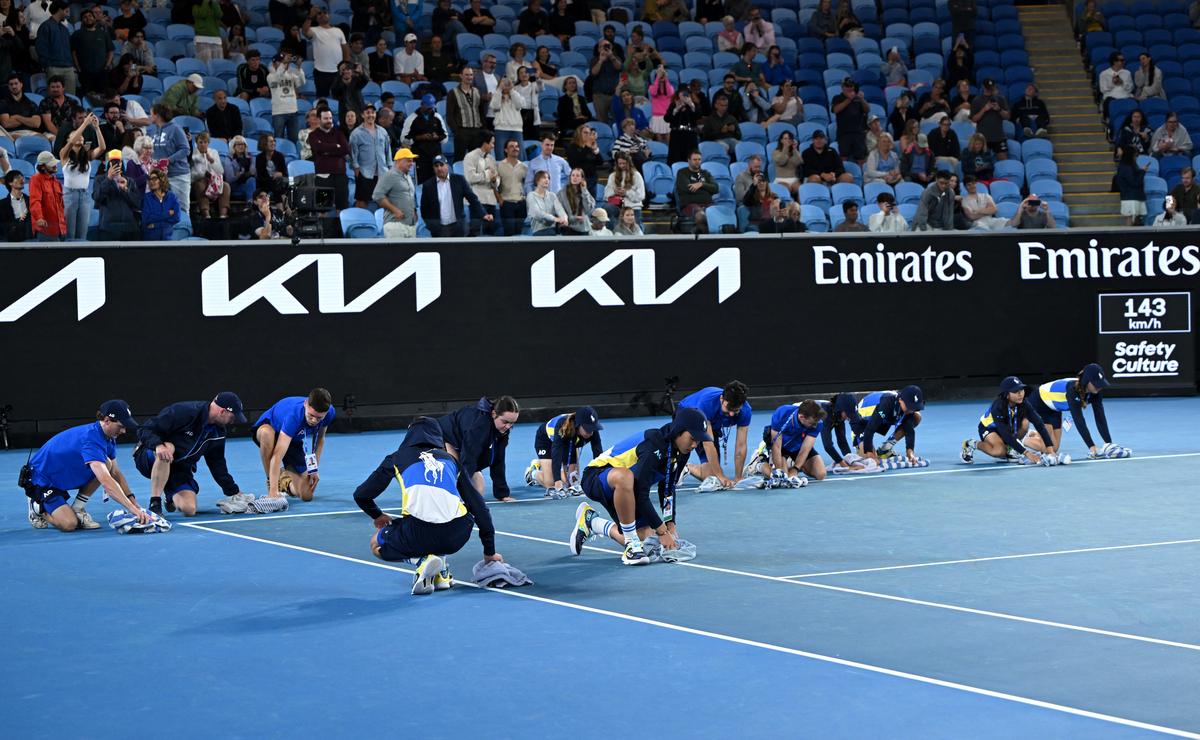 Ball kids are pictured wiping the tennis court as rain delays play at Australian Open - Melbourne Park, Melbourne, in 2023.