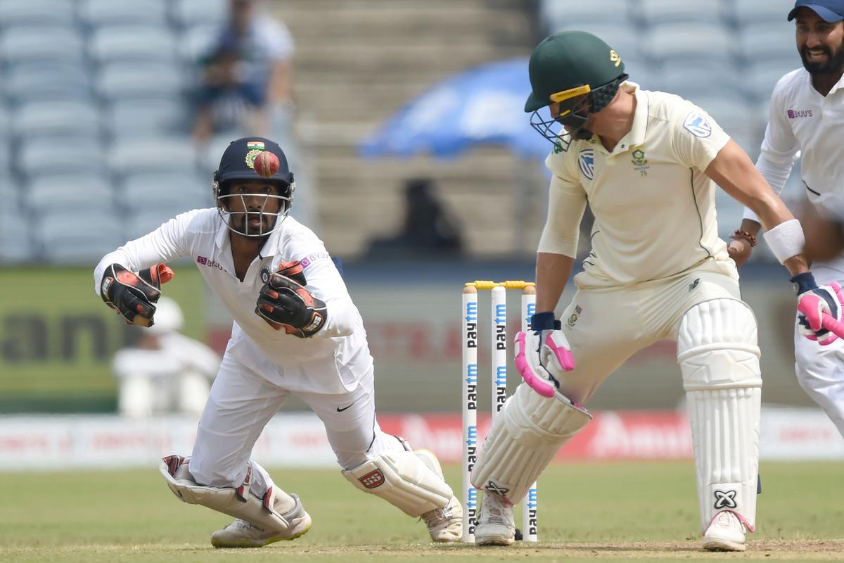 India’s wicketkeeper Wriddhiman Saha (L) attempts to take a catch to dismiss South Africa captain Faf du Plessis (R) during the fourth day of play of the second test cricket match between India and South Africa.