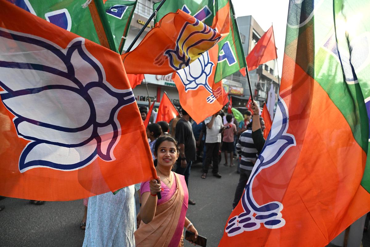 BJP activist carries the party flag during the closing event.