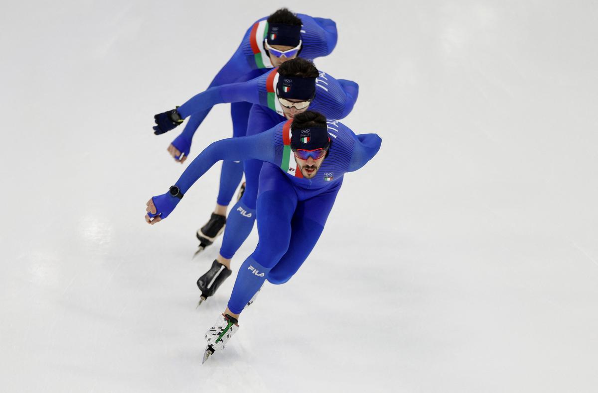 Athletes of Italy speed-skating on artificial snow at the Beijing 2022 Winter Olympic Games, in Beijing, China.