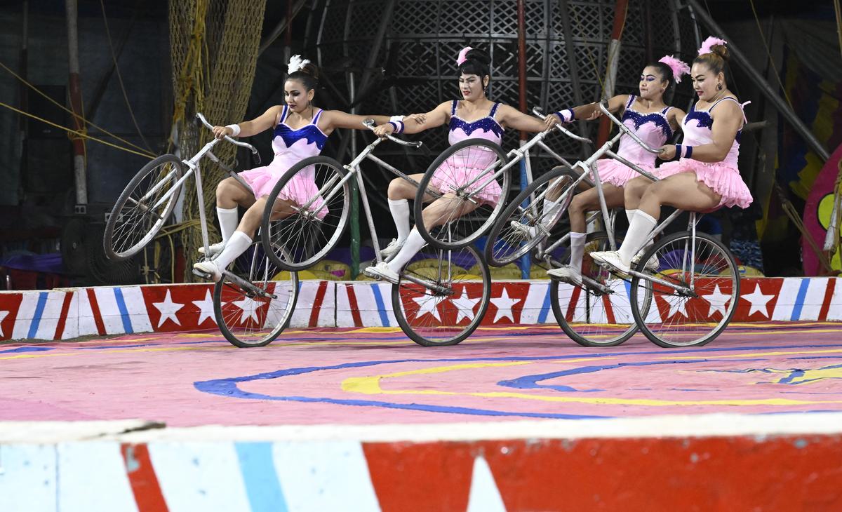 An  all-women team perform acrobatics while cycling 