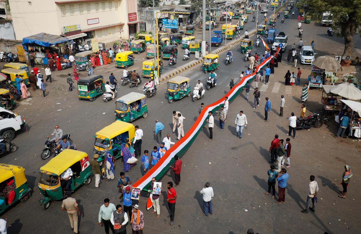 Fans hold an Indian national flag and cheer for the victory of the Indian cricket team in the ICC Men’s Cricket World Cup final against Australia, on a street in Ahmedabad, on November 18, 2023.