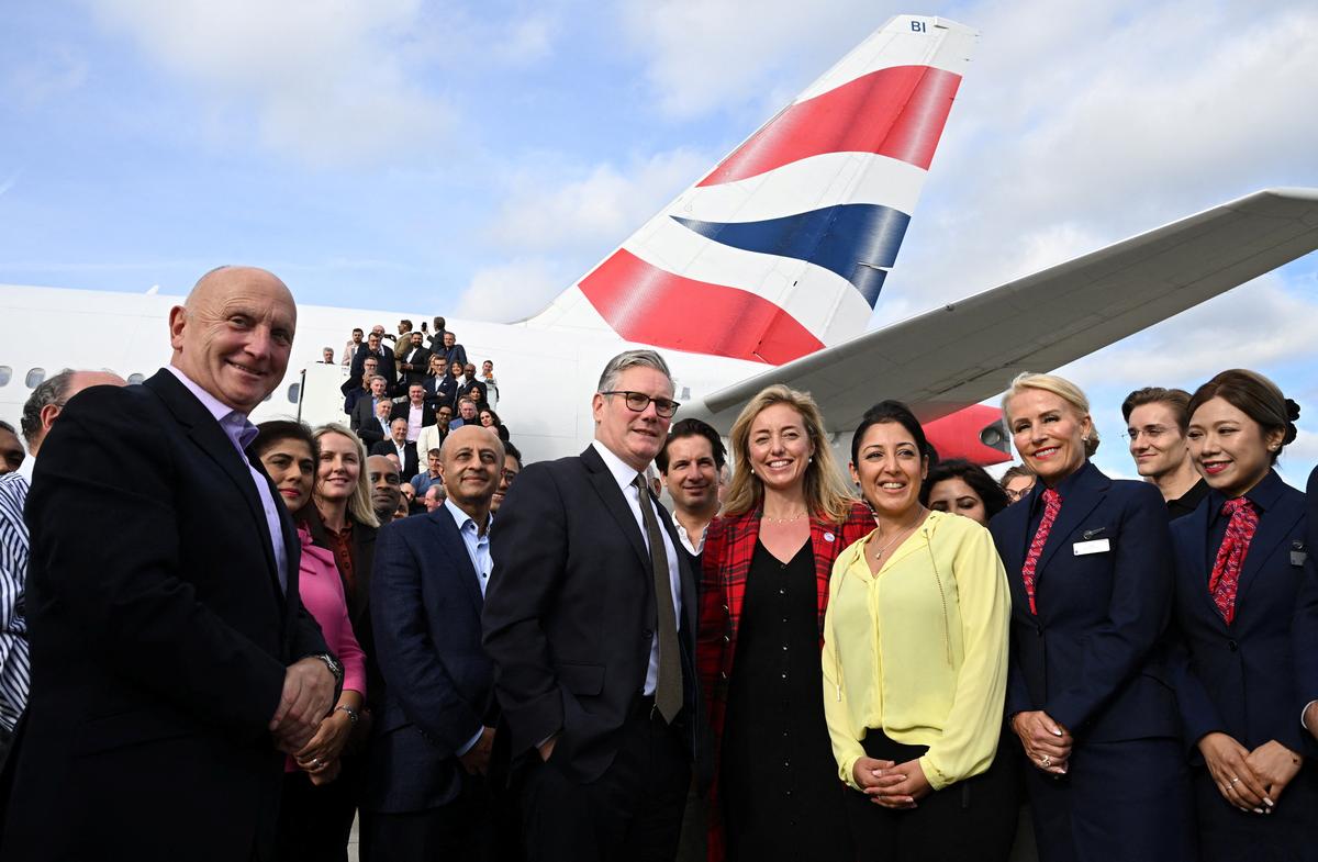 Britain’s Prime Minister Keir Starmer poses for a photo with his business delegation before departing London Heathrow Airport as they head to India to meet with Indian Prime Minister Narendra Modi and promote the recently signed trade deal, in London on October 7, 2025.