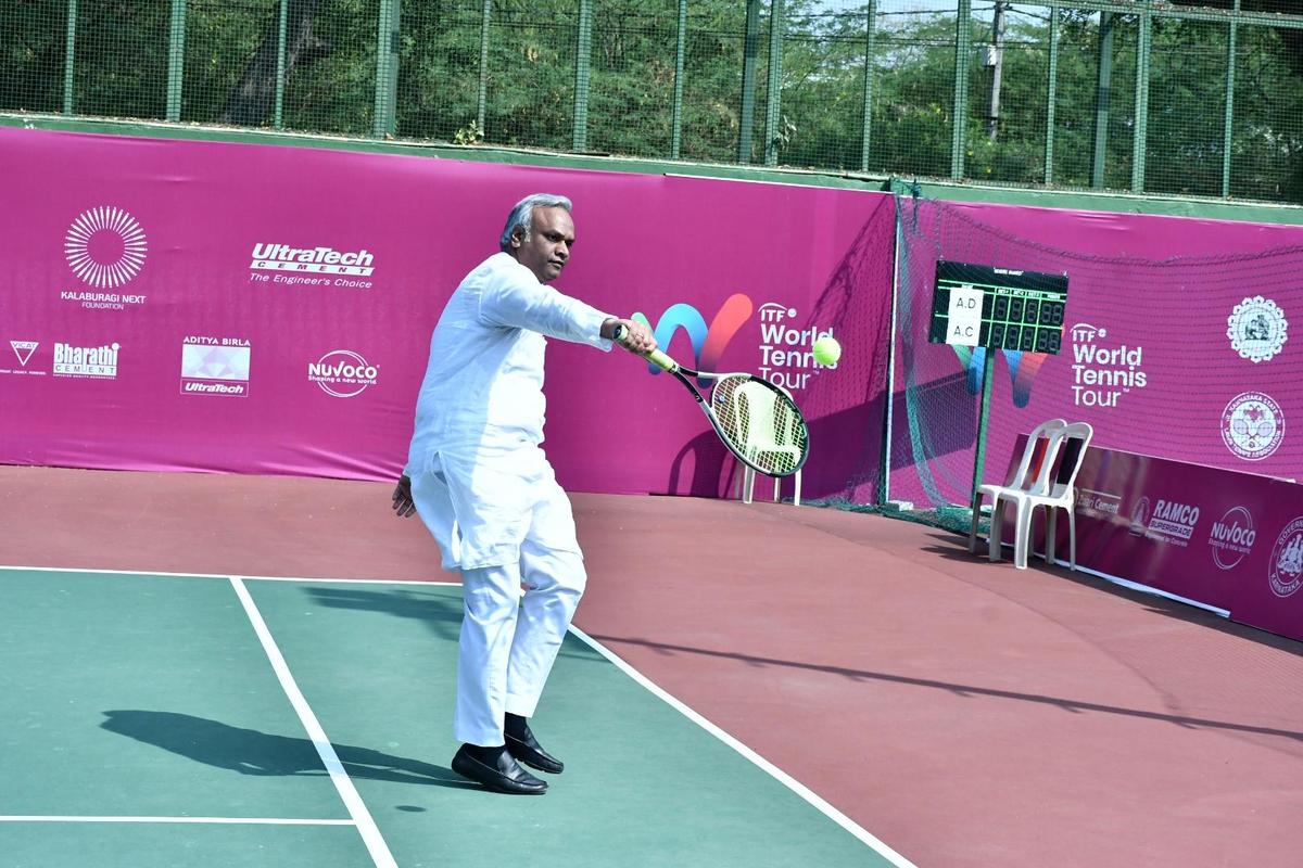 Il ministro RDPR del Karnataka, Priyank Kharge, gioca un tiro dopo aver interrotto il torneo di tennis femminile ITF W35 allo stadio Chandrashekar Patil di Kalaburagi il 3 marzo 2026.