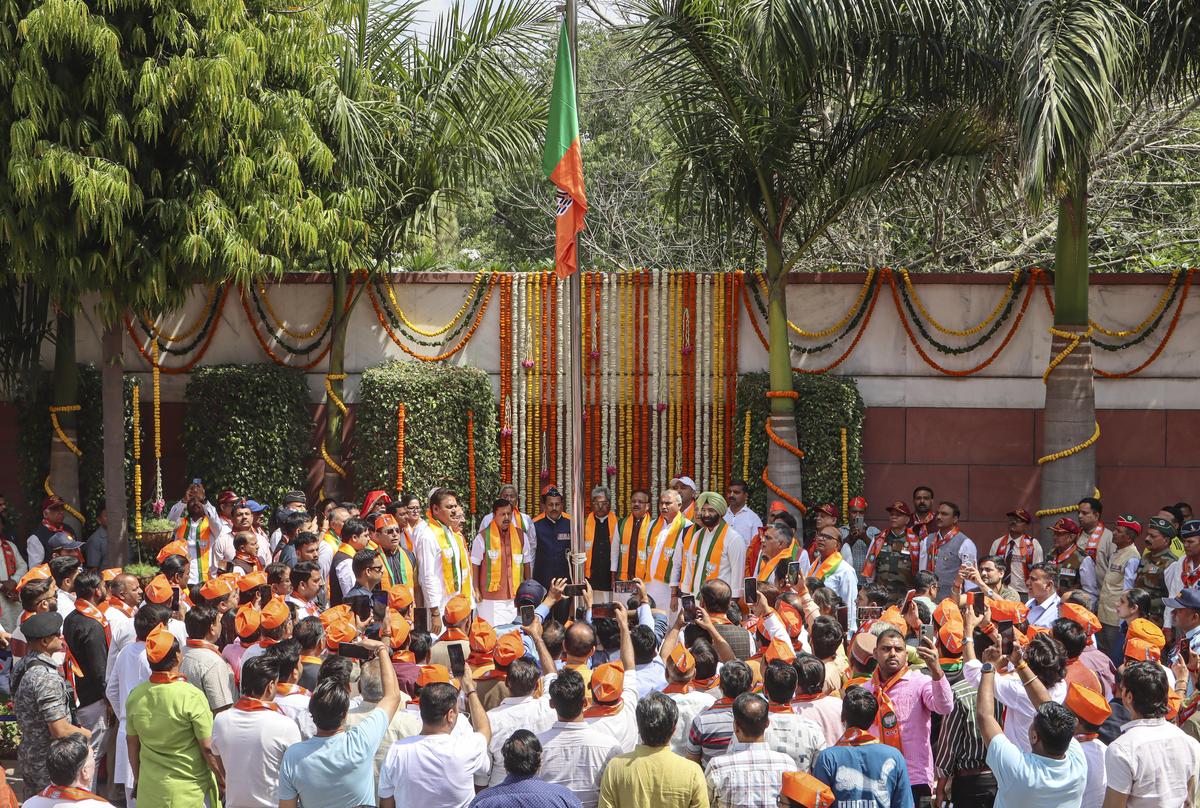 BJP National President Nitin Nabin, and others, stand after hoisting the party's flag on the occassion of BJP's foundation day, at party headquarters in New Delhi.