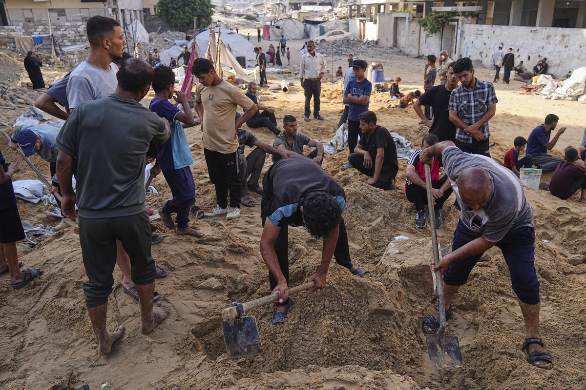 Palestinians dig through sand looking for belongings after an Israeli strike hit a displacement tent camp in Gaza City, Saturday, June 28, 2025. Palestinians dig through sand looking for belongings after an Israeli strike hit a displacement tent camp in Gaza City, Saturday, June 28, 2025.