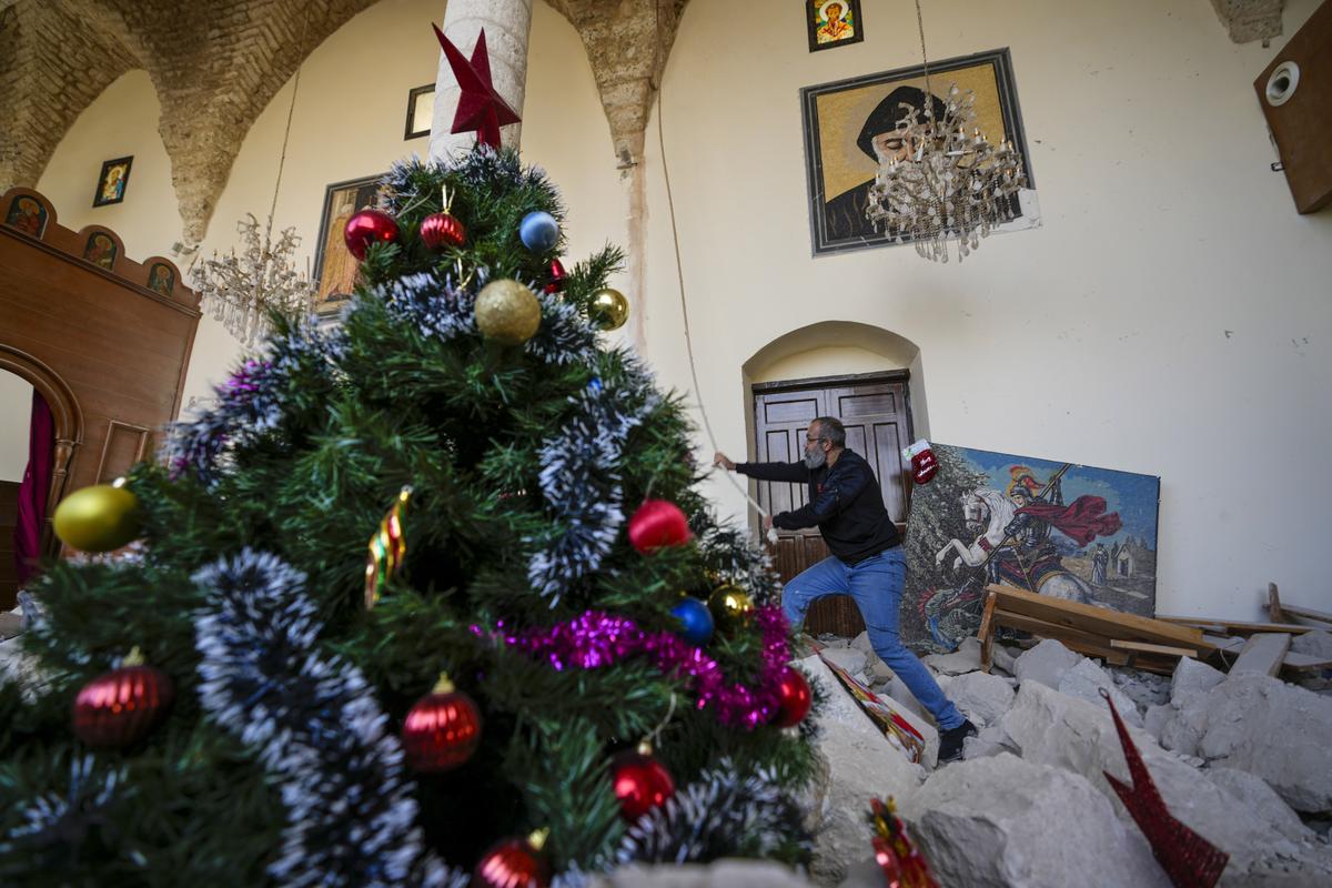 Georges Elia rings the bells after he decorated a Christmas tree inside St. George Melkite Catholic Church, that was destroyed by Israeli airstrike, in the town of Dardghaya in southern Lebanon, on December 22, 2024.