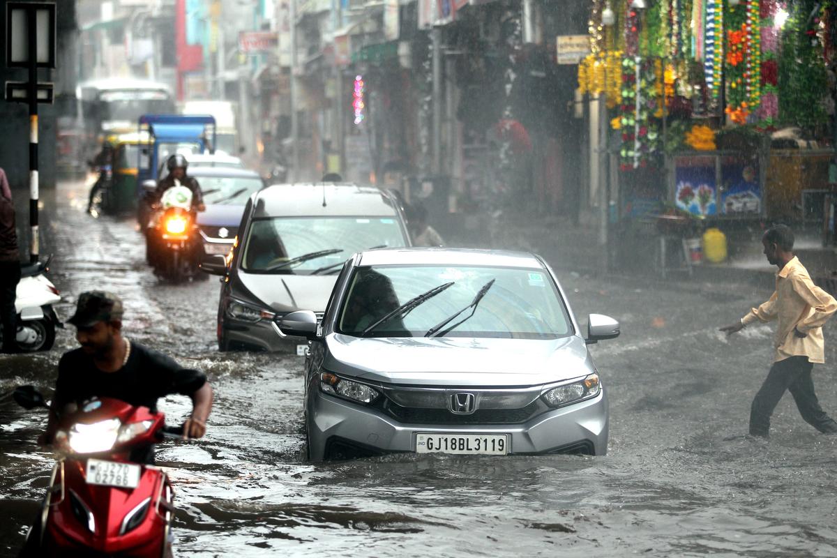Vehicles pass through a waterlogged road amid heavy rain in Ahmedabad on September 17, 2023. 