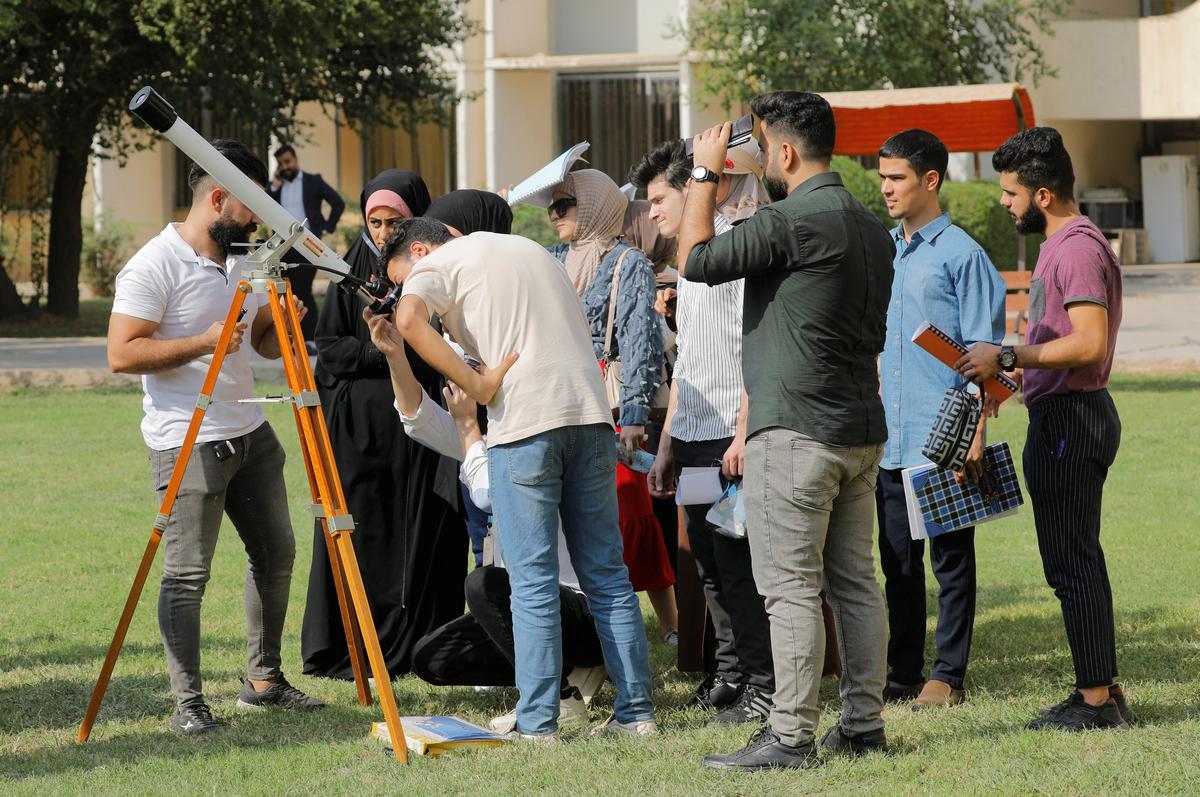People observe a partial solar eclipse in Baghdad, Iraq. 