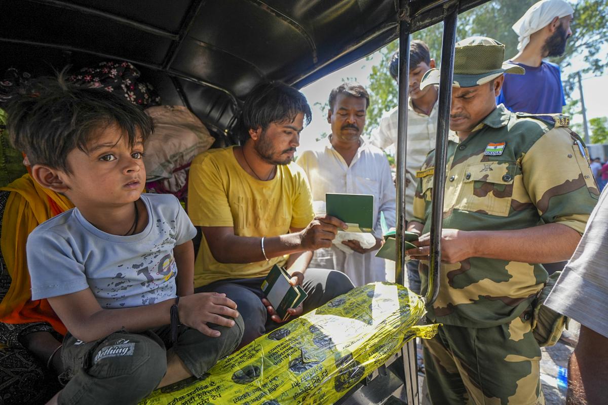 A security personnel checks the passports of Pakistani nationals as they arrive at the Attari-Wagah border to move to their country, near Amritsar on April 27, 2025. A security personnel checks the passports of Pakistani nationals as they arrive at the Attari-Wagah border to move to their country, near Amritsar on April 27, 2025.
