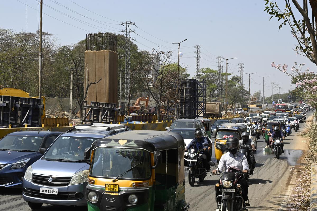 Motorists inch through traffic snarls as construction of multi-level flyovers progresses on the busy IIIT Road near the Gachibowli junction in Hyderabad on Friday.