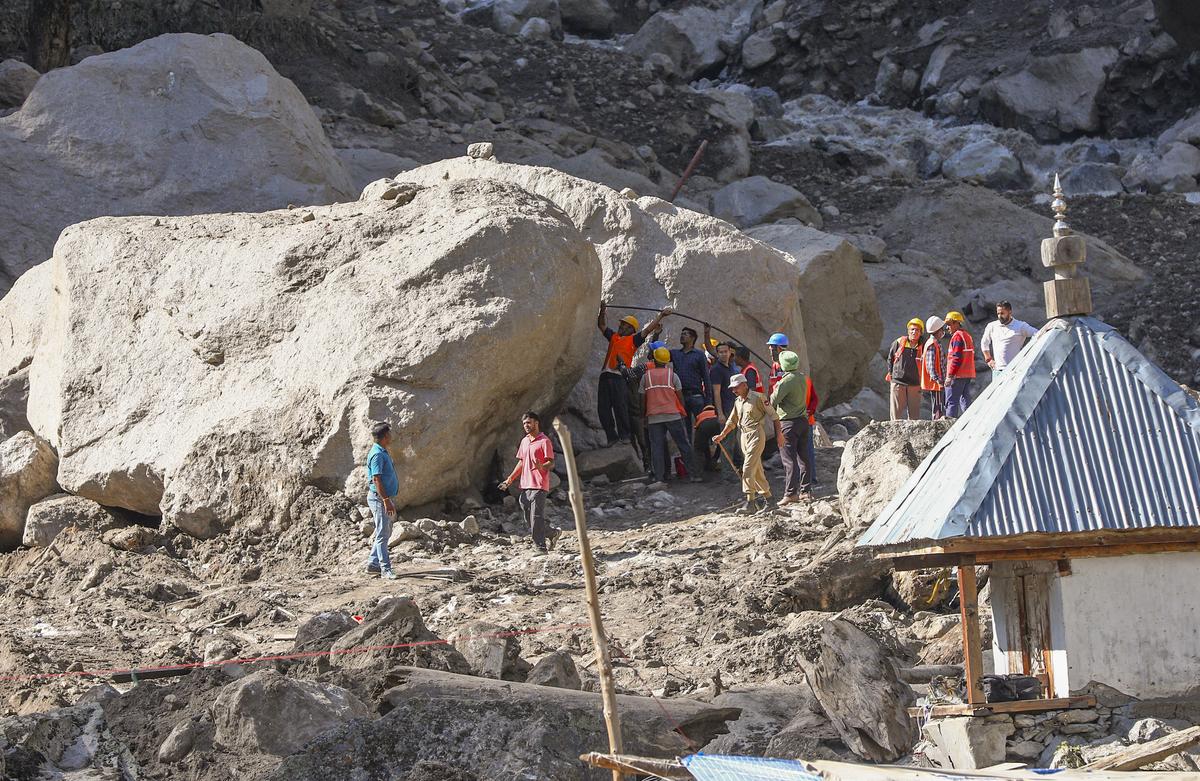 Workers stand near boulders during a search and rescue operation after flash flood triggered by cloudburst, at Chisoti village, in Kishtwar district, Jammu and Kashmir on August 16, 2025. Workers stand near boulders during a search and rescue operation after flash flood triggered by cloudburst, at Chisoti village, in Kishtwar district, Jammu and Kashmir on August 16, 2025.