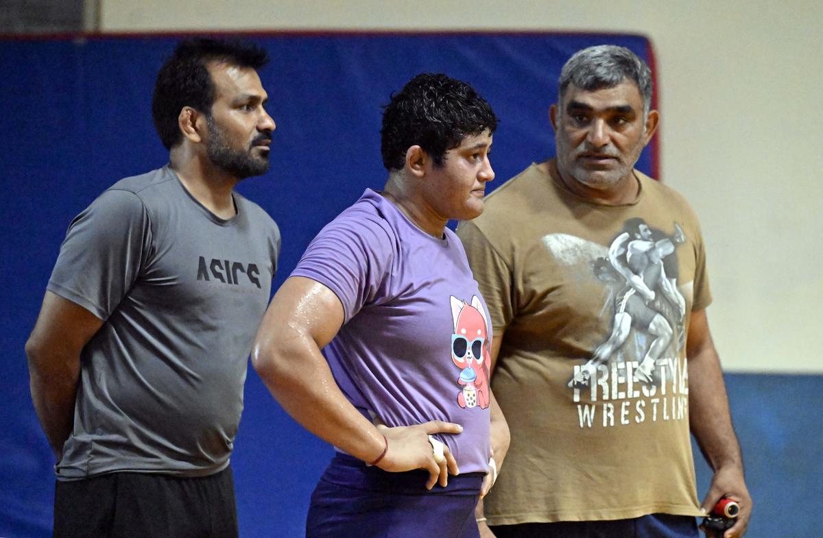 Wrestler Reetika Hooda with her coaches Mandeep (left) and Kuldeep Sehrawat (right), during a practice session.