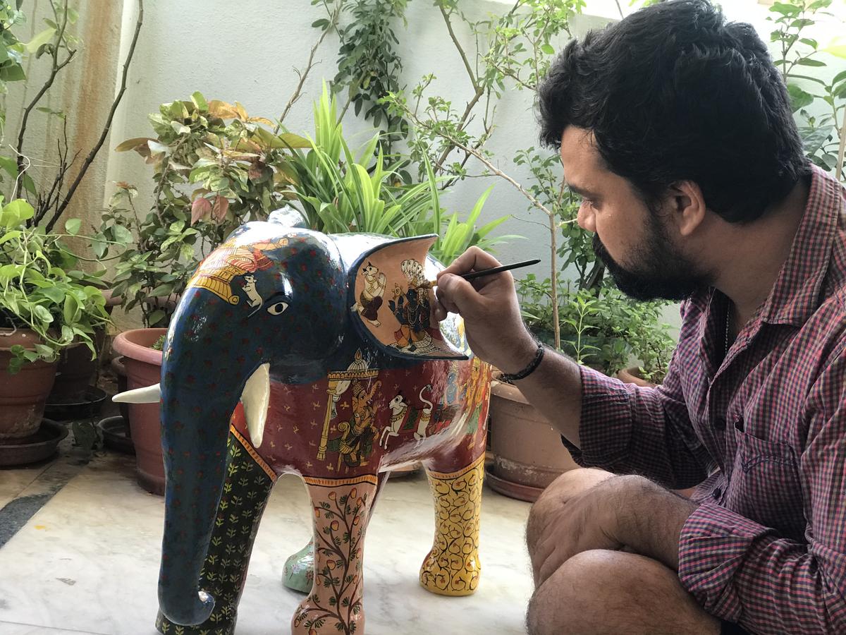 Rakesh painting a wooden elephant