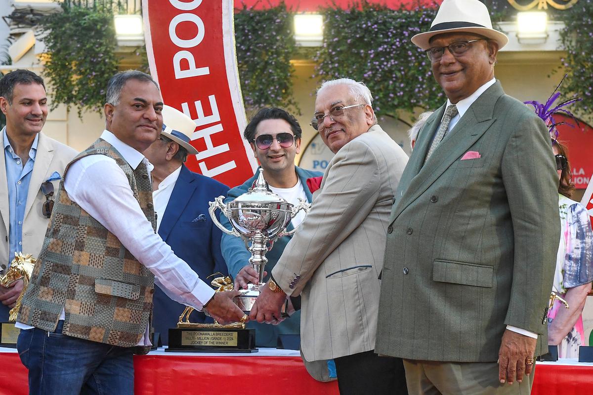 Adar C. Poonawalla gives away the winnerâs trophy to the owners of Excellent Lass, from left, Ashok Ranpise, Daulat Chhabria and Rajendran.