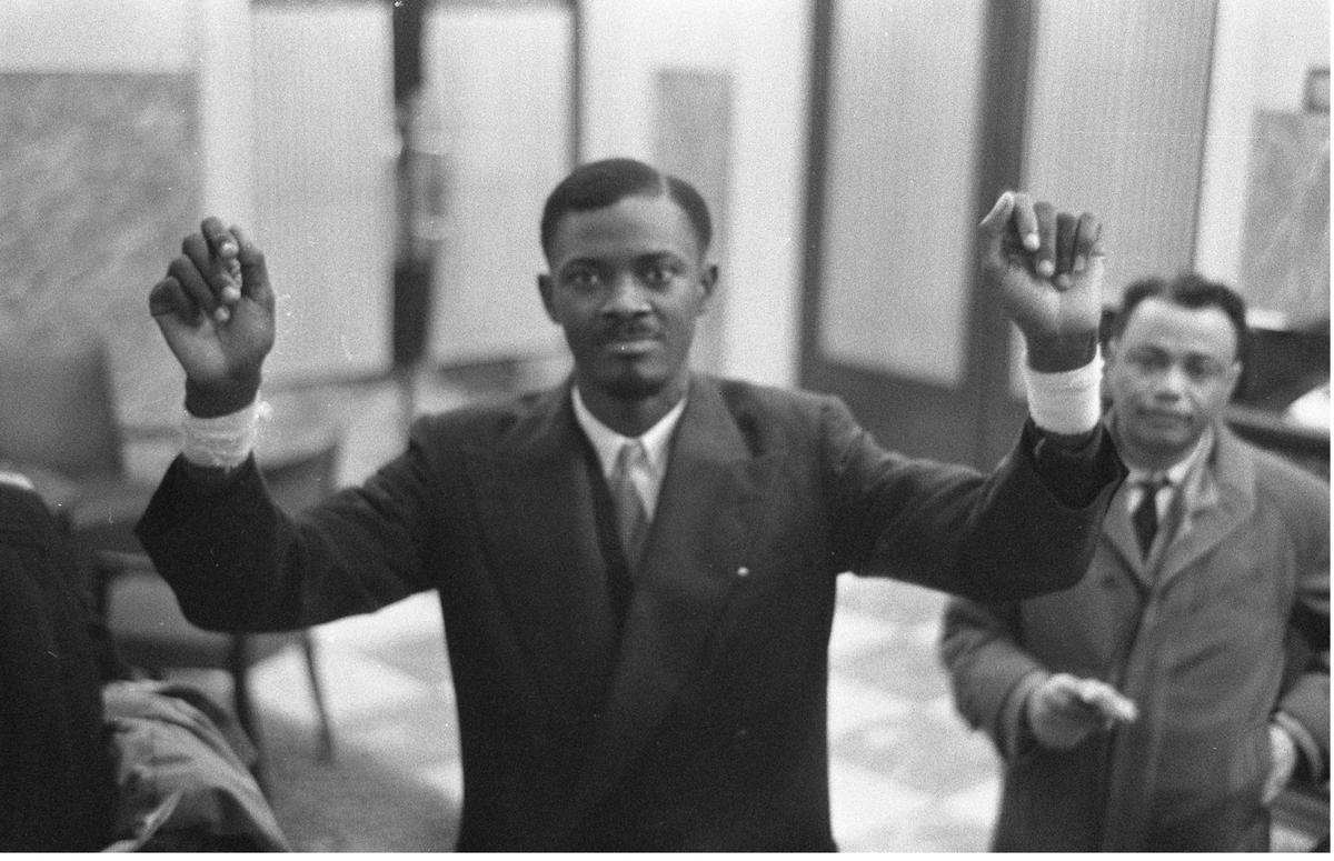 A photo of Patrice Lumumba in Brussels (1960) holding up his arms to show his wounds from prison, from the exhibition The Undying Flame of Patrice Lumumba A photo of Patrice Lumumba in Brussels (1960) holding up his arms to show his wounds from prison, from the exhibition The Undying Flame of Patrice Lumumba