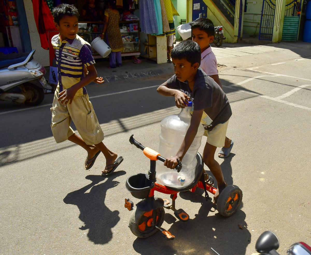 Children carry water cans to fetching drink water in Bangarappanagar, Bengaluru