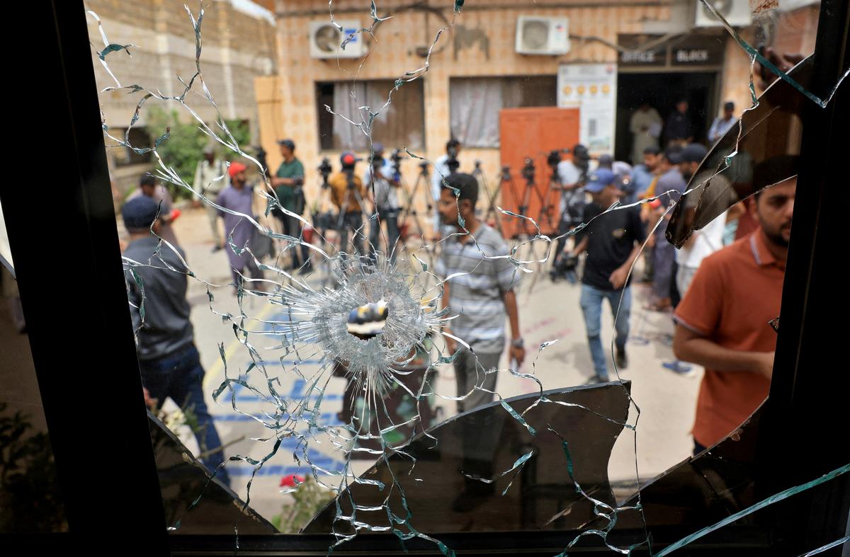Members of media are seen through a broken glass window inside the premises of the district Malir jail after dozens of prisoners escaped from the jail on the outskirts of Karachi, Pakistan, on June 3, 2025. 