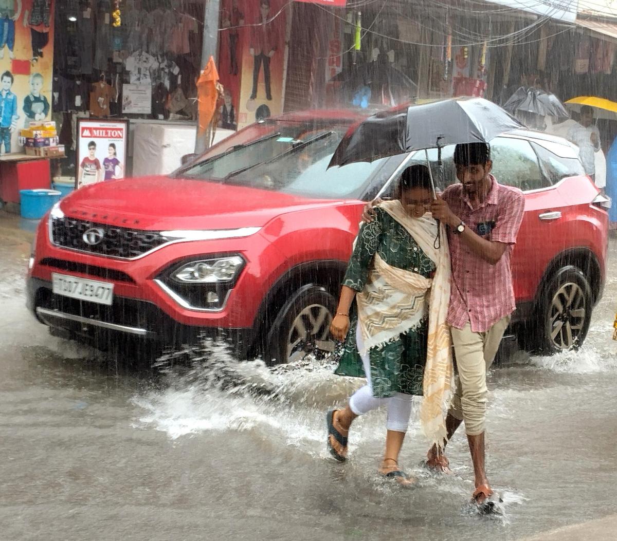 शनिवार (25 अक्टूबर) को तिरुपति में भारी बारिश के कारण जलजमाव वाली सड़क से गुजरते हुए पैदल यात्री।  