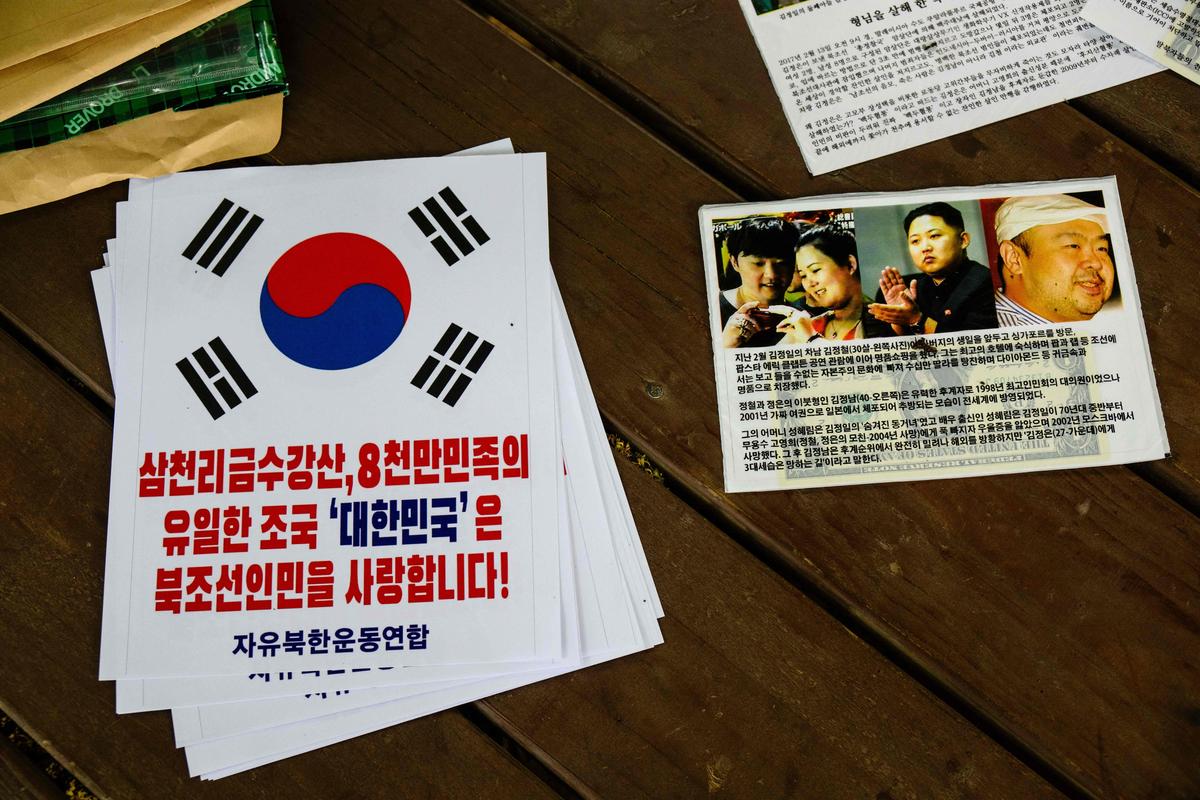 A leaflet (R) containing a US dollar bill is seen next to a poster (L) reading 'Republic of Korea loves the North Korean people' during an AFP interview with North Korean defector Park Sang-hak in Seoul on June 25, 2024. Park considers the propaganda balloons he floats into his homeland to be part of a tradition of psychological warfare, and vows to keep going until Kim Jong Un's regime falls. The son of a North Korean double agent who escaped his country in 1999, Park has been sending balloons loaded with anti-regime propaganda leaflets, US dollar bills and USB drives of K-pop across the border for nearly 20 years. (Photo by Anthony WALLACE / AFP) / To go with 'SKOREA-NKOREA-DIPLOMACY-CONFLICT, PROFILE' by Kang Jin-kyu and Cat Barton
