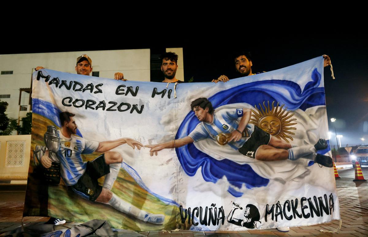 Argentina fans display a Lionel Messi and Diego Maradona banner after training in Doha, Qatar
