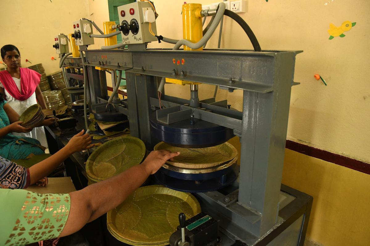 Volunteer looks on as women work on the machine