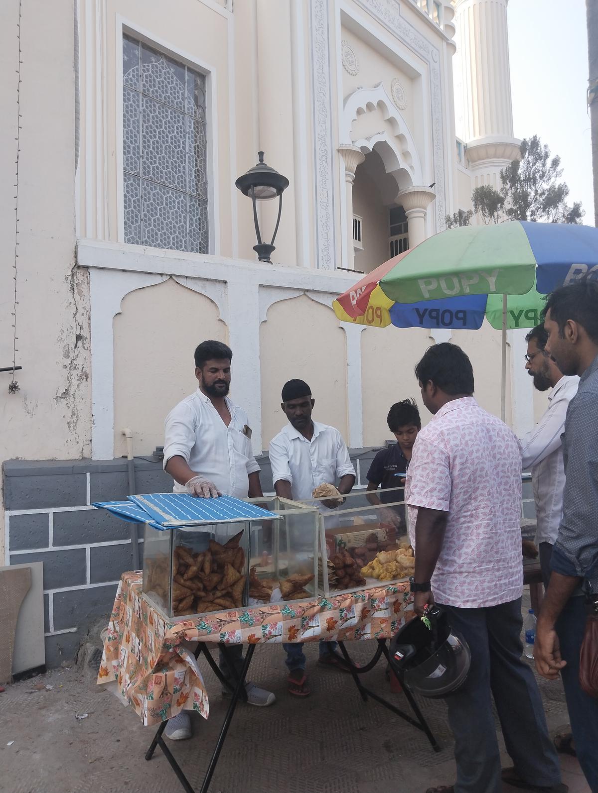 Sulfikar J (left) selling snacks in front of Palayam Juma Masjid