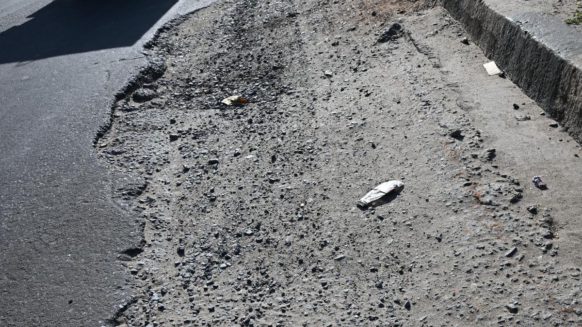 Puddles of water, broken surface make driving a nightmore on service road at Ariyamangalam