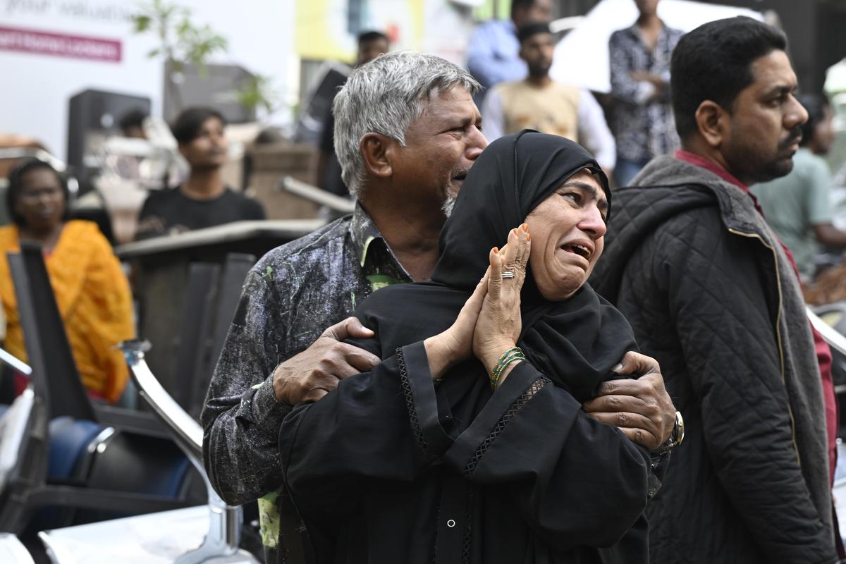 Family members break down at the site of a fire that broke out in a furniture shop on the ground floor of a four-storey building at Chirag Ali Lane in Nampally, Hyderabad, on Saturday.