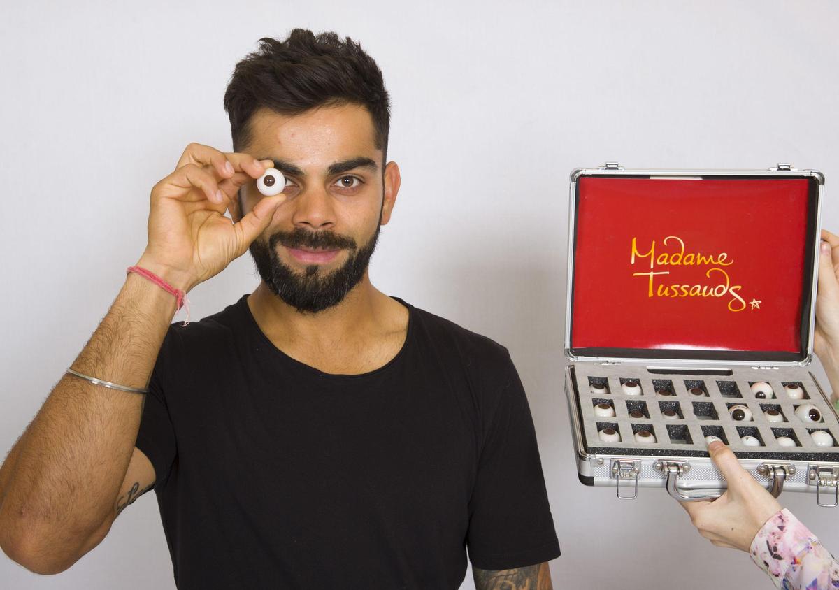 Il giocatore di cricket indiano Virat Kohli posa per una foto mentre sceglie il modello del bulbo oculare per la sua controfigura in cera.