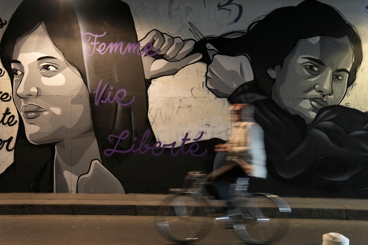 A mural depicting women cutting their hair to show support for Iranian protesters, in a tunnel in Paris, October 5, 2022. 