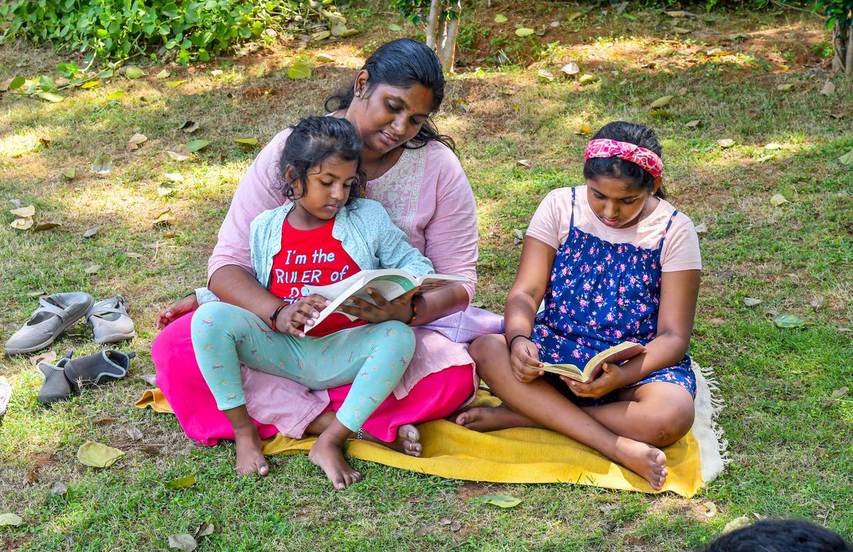 People reading books under the shade of trees at VMRDA Central Park as part of a quiet reading initiative called Vizag Reads in Visakhapatnam. 