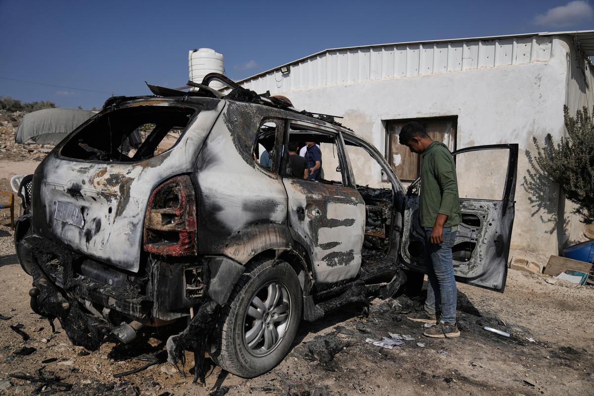 Palestinians survey damage in an industrial zone following an attack by Israeli settlers the previous day in the West Bank village of Beit Lid, near Tulkarm, Wednesday, Nov. 12, 2025.