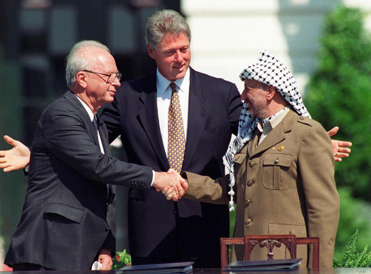 Israeli Prime Minister Yitzhak Rabin, left, and Palestinian leader Yasser Arafat shake hands marking the signing of the peace accord between Israel and the Palestinians, in Washington, Sept. 13, 1993.