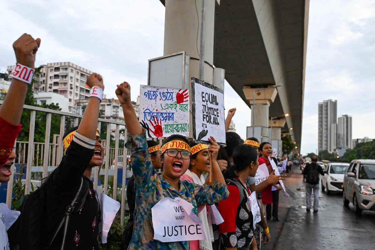 Health professionals and activists shout slogans and hold posters as they form a long human chain during a demonstration to condemn the rape and murder of a doctor, along a street in Kolkata on September 3, 2024. 