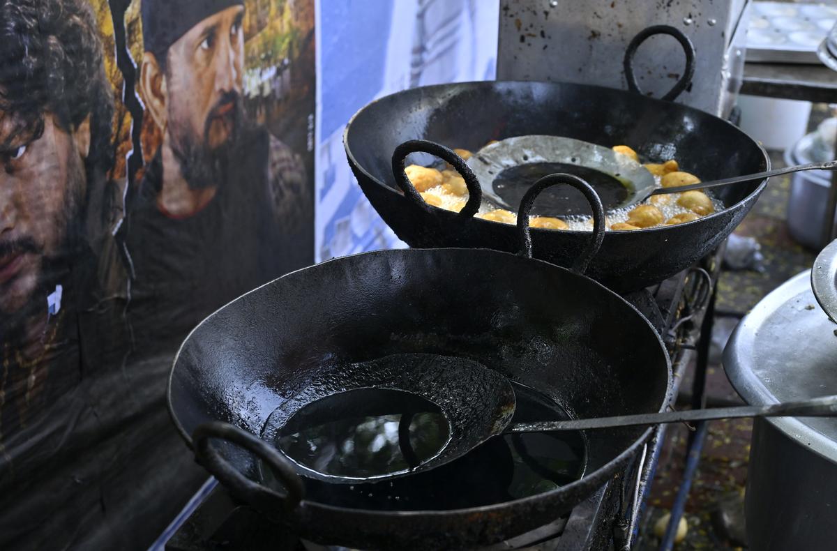 Hot oil and fried snacks juxtaposed against an unclean environment, raising concerns about hygiene standards at a street food stall in Hyderabad.