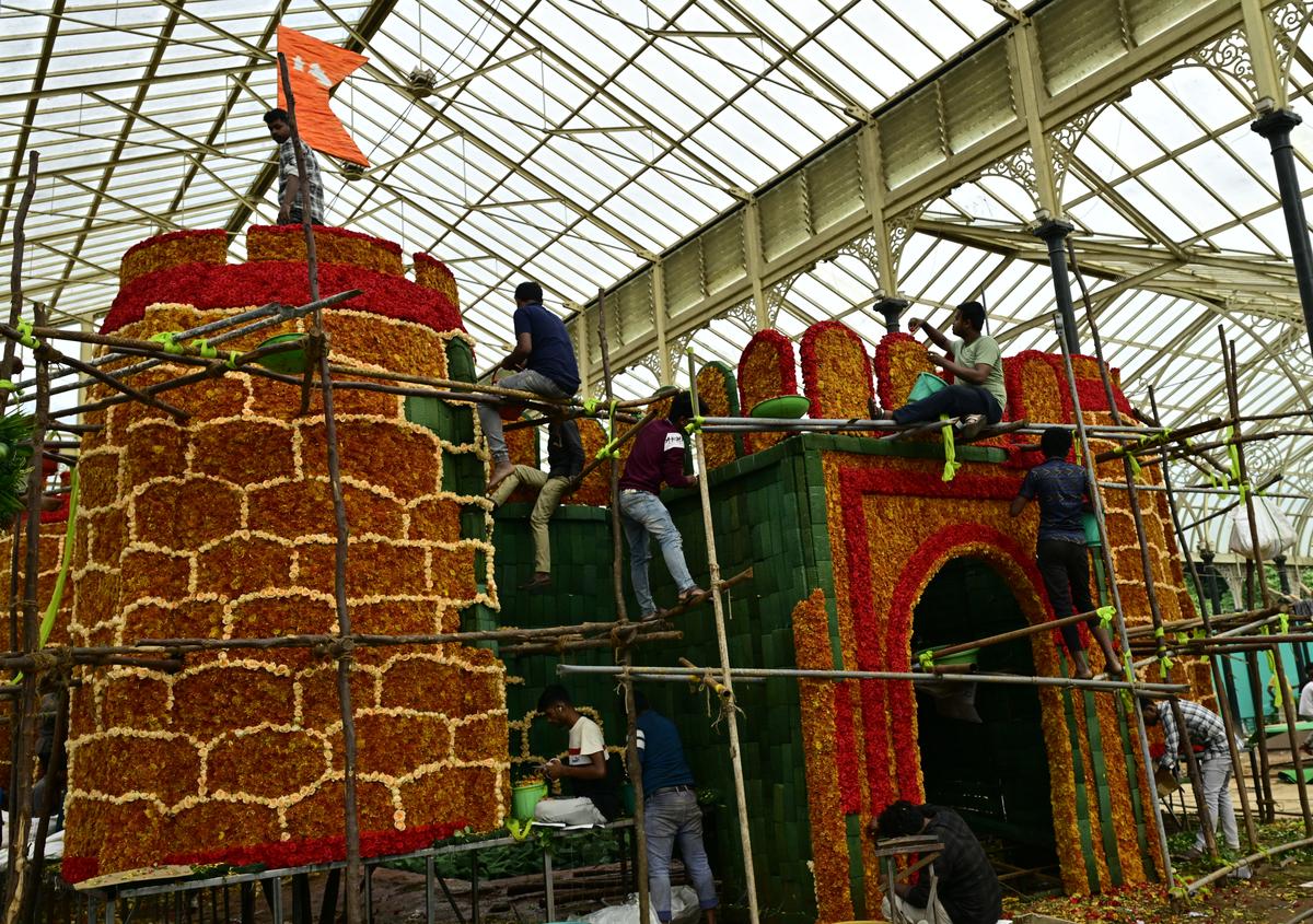 The workers who use brown Dutch chrysanthemums with red and peach -colored roses to make 'Kittur's Castle'. This model of the castle will be the center of this year's Independence Day flower show in Lalbagh in Bengaluru.